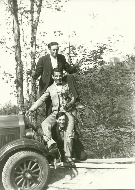 Charles Hubbard, George Banta, and Horace clowning around on an old car.