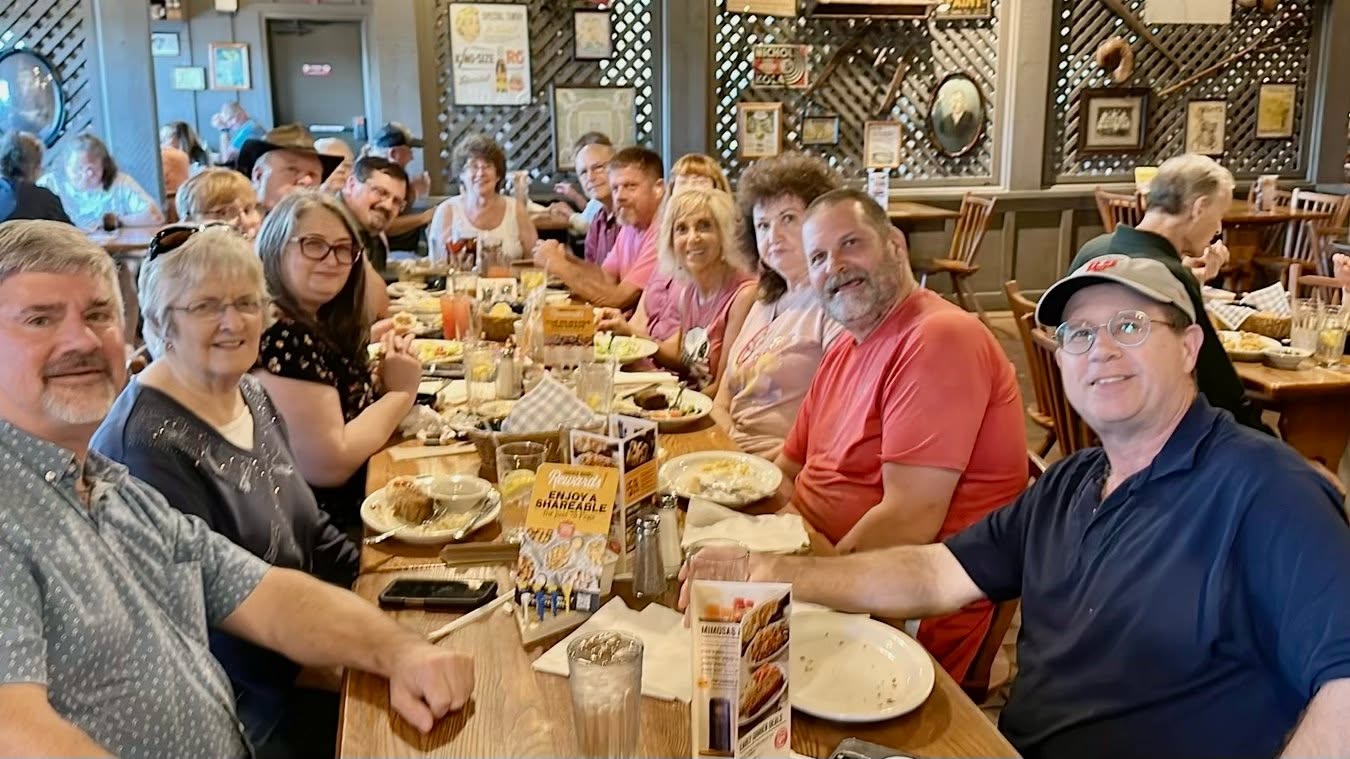 Family gathered around a long restaurant table the night before the reunion.